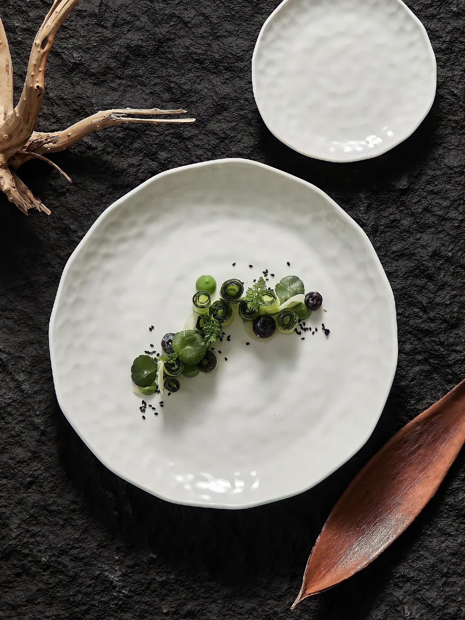 Close-up of plated gourmet course on ceramic plate